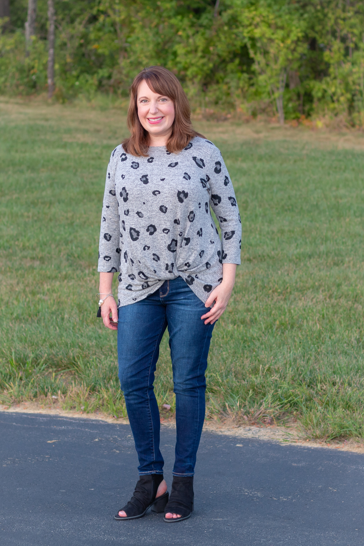 Dianna Wearing a Grey Leopard Print Twist Top, Skinny Jeans, and Black Open Toe Booties